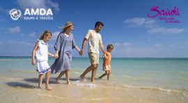 A young family of four walking hand in hand together along the beach in the Farasan Islands